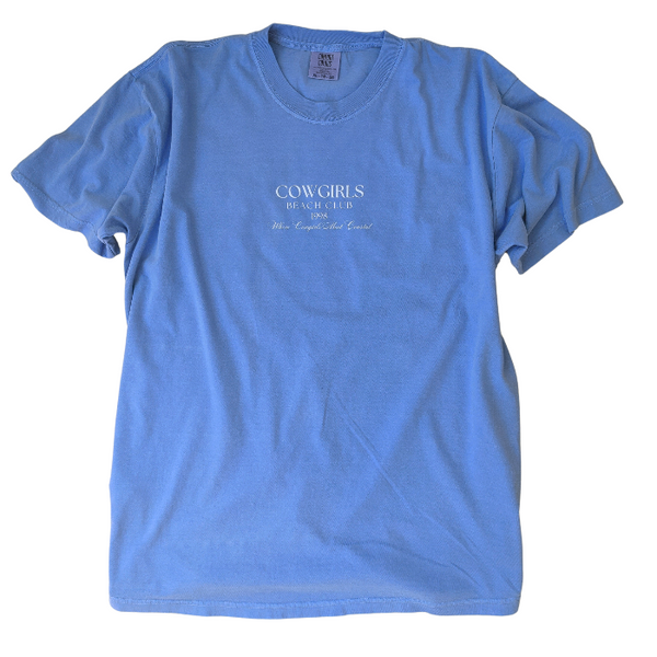 This Cowgirls Coastal Beach Club Graphic Tee is the perfect blend of western charm and summer style! This blue tee features a minimal front text and a fun beachy western graphic on the back—designed for trend-lovers and sunshine-chasers. Great for pairing with denim shorts, cowboy boots, or a trucker hat for the full cowgirl vibe. For that oversized, slouchy look, size up!