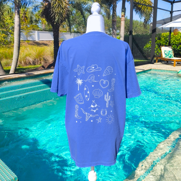 This Cowgirls Coastal Beach Club Graphic Tee is the perfect blend of western charm and summer style! This blue tee features a minimal front text and a fun beachy western graphic on the back—designed for trend-lovers and sunshine-chasers. Great for pairing with denim shorts, cowboy boots, or a trucker hat for the full cowgirl vibe. For that oversized, slouchy look, size up!