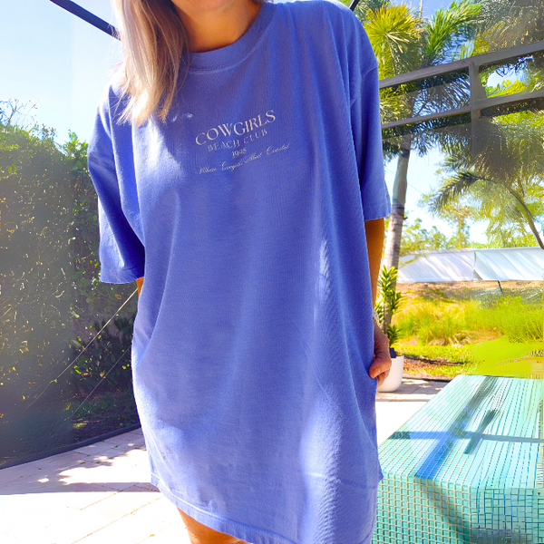 This Cowgirls Coastal Beach Club Graphic Tee is the perfect blend of western charm and summer style! This blue tee features a minimal front text and a fun beachy western graphic on the back—designed for trend-lovers and sunshine-chasers. Great for pairing with denim shorts, cowboy boots, or a trucker hat for the full cowgirl vibe. For that oversized, slouchy look, size up!