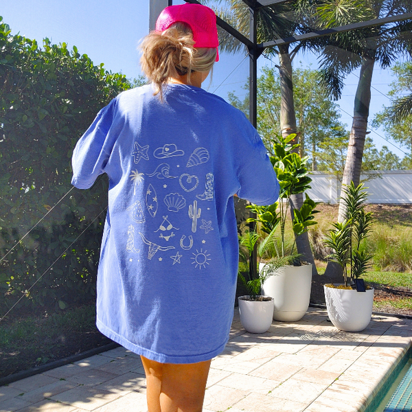 This Cowgirls Coastal Beach Club Graphic Tee is the perfect blend of western charm and summer style! This blue tee features a minimal front text and a fun beachy western graphic on the back—designed for trend-lovers and sunshine-chasers. Great for pairing with denim shorts, cowboy boots, or a trucker hat for the full cowgirl vibe. For that oversized, slouchy look, size up!