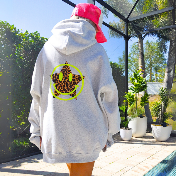Add a pop of personality to your closet with this neon leopard star smiley hoodie! This cozy, lightweight graphic sweatshirt is the perfect blend of Y2K aesthetic, preppy style, and fun vibes. Featuring a bold neon yellow happy face and an animal print star, it's made to stand out from the crowd. Want that trendy oversized look? Size up from your usual size for the perfect slouchy fit! Perfect for summer nights, beach trips, or lounging in style. Makes a great gift for her too!