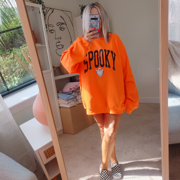 Unleash your spooky style with our Spooky Ghost Sweatshirt! Featuring a cute ghost with the word SPOOKY in varsity lettering and a distressed design, this sweatshirt is perfect for Halloween parties and the entire spooky season. Size up for an oversized fit. Get yours today and join the ghost squad!