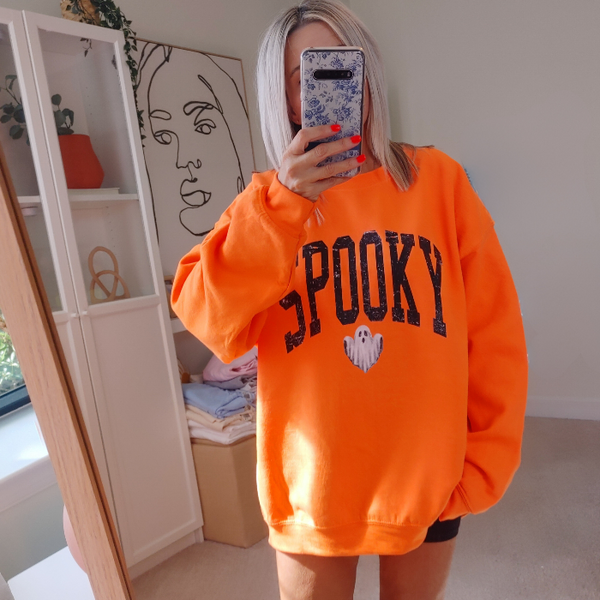 Unleash your spooky style with our Spooky Ghost Sweatshirt! Featuring a cute ghost with the word SPOOKY in varsity lettering and a distressed design, this sweatshirt is perfect for Halloween parties and the entire spooky season. Size up for an oversized fit. Get yours today and join the ghost squad!