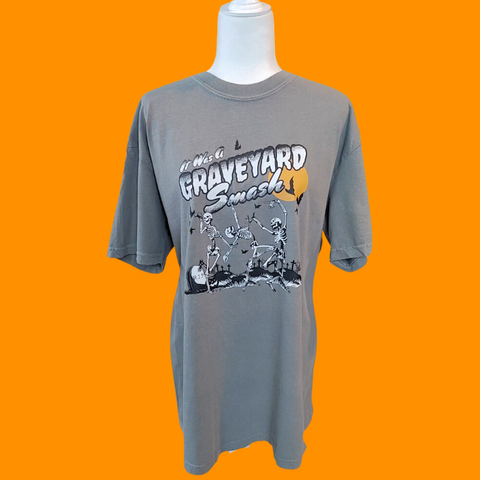 This Halloween, make a statement with our Halloween graveyard smash dancing skeleton t-shirt! Featuring a retro skeleton design, this shirt is perfect for the spooky season and will add a touch of vintage style to your fall wardrobe. Available in both comfort color t-shirts and Gildan crewneck sweatshirts, size up for an oversized fit. Get yours today!