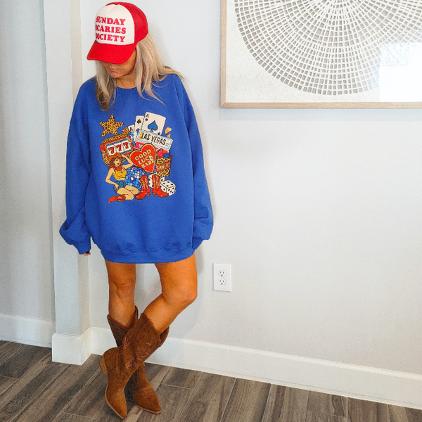 Turn up the lucky vibes with this bold and retro-inspired Las Vegas graphic sweatshirt. Designed in a vibrant royal blue, this cozy pullover features the ultimate “Good Luck Babe” casino theme—complete with slot machine sevens, cowgirl art, leopard-print star, poker cards, and classic Western boots. It’s the perfect mix of vintage charm, playful style, and standout color.