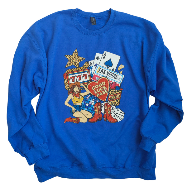 Turn up the lucky vibes with this bold and retro-inspired Las Vegas graphic sweatshirt. Designed in a vibrant royal blue, this cozy pullover features the ultimate “Good Luck Babe” casino theme—complete with slot machine sevens, cowgirl art, leopard-print star, poker cards, and classic Western boots. It’s the perfect mix of vintage charm, playful style, and standout color.