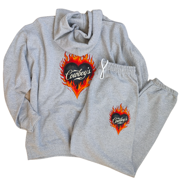 This matching Cowboys flame sweatshirt and sweatpants set delivers bold western style with all-day comfort. Featuring a fiery heart “Cowboys” graphic, this gray lounge set is perfect for cozy days, casual outings, travel, or effortless cowgirl street style.