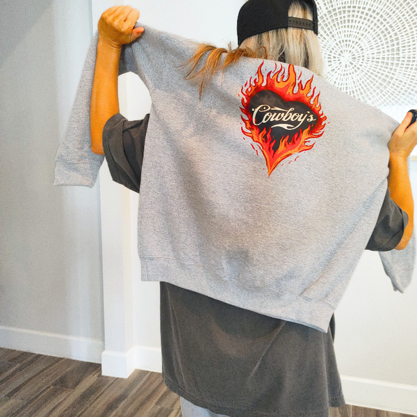 Turn up the western vibes with this Cowboys flame hoodie sweatshirt, featuring a bold flaming heart “Cowboys” graphic that makes a statement from every angle. Designed on a classic sports gray pullover hoodie, this piece blends edgy cowgirl style with everyday comfort—perfect for casual wear, concerts, or laid-back weekends.

This hoodie is made with a soft and cozy 50% cotton / 50% polyester blend, giving it warmth without feeling heavy. 