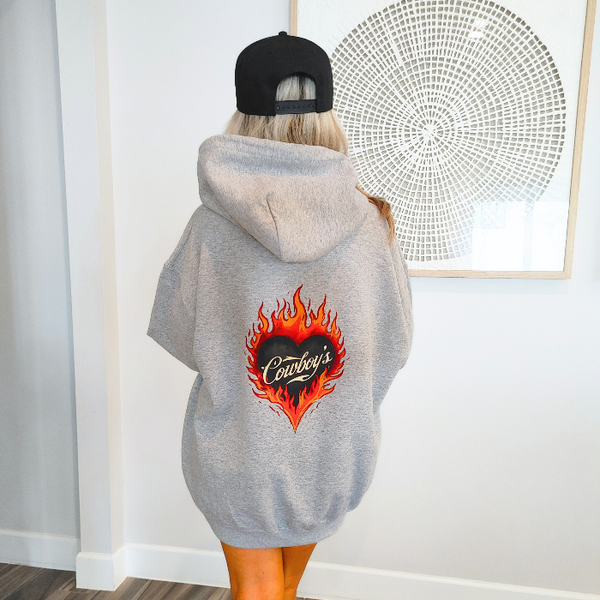 Turn up the western vibes with this Cowboys flame hoodie sweatshirt, featuring a bold flaming heart “Cowboys” graphic that makes a statement from every angle. Designed on a classic sports gray pullover hoodie, this piece blends edgy cowgirl style with everyday comfort—perfect for casual wear, concerts, or laid-back weekends.

This hoodie is made with a soft and cozy 50% cotton / 50% polyester blend, giving it warmth without feeling heavy. 