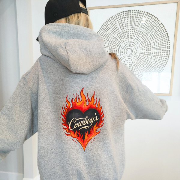 Turn up the western vibes with this Cowboys flame hoodie sweatshirt, featuring a bold flaming heart “Cowboys” graphic that makes a statement from every angle. Designed on a classic sports gray pullover hoodie, this piece blends edgy cowgirl style with everyday comfort—perfect for casual wear, concerts, or laid-back weekends.

This hoodie is made with a soft and cozy 50% cotton / 50% polyester blend, giving it warmth without feeling heavy. 