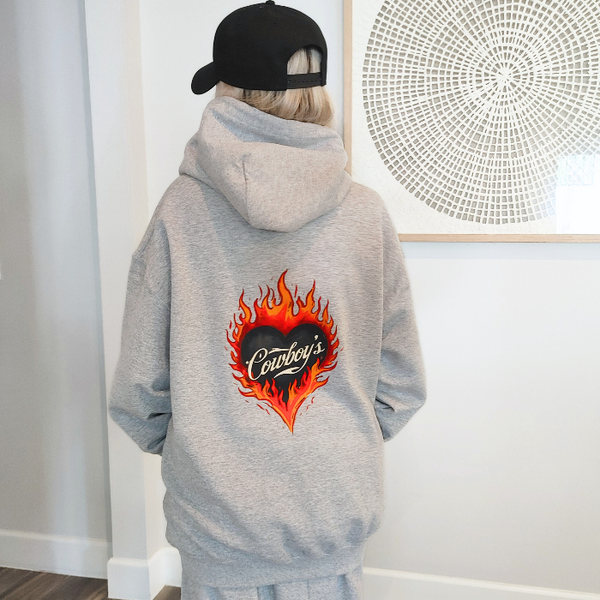 Turn up the western vibes with this Cowboys flame hoodie sweatshirt, featuring a bold flaming heart “Cowboys” graphic that makes a statement from every angle. Designed on a classic sports gray pullover hoodie, this piece blends edgy cowgirl style with everyday comfort—perfect for casual wear, concerts, or laid-back weekends.

This hoodie is made with a soft and cozy 50% cotton / 50% polyester blend, giving it warmth without feeling heavy. 