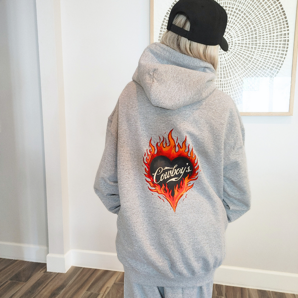 Turn up the western vibes with this Cowboys flame hoodie sweatshirt, featuring a bold flaming heart “Cowboys” graphic that makes a statement from every angle. Designed on a classic sports gray pullover hoodie, this piece blends edgy cowgirl style with everyday comfort—perfect for casual wear, concerts, or laid-back weekends.

This hoodie is made with a soft and cozy 50% cotton / 50% polyester blend, giving it warmth without feeling heavy. 