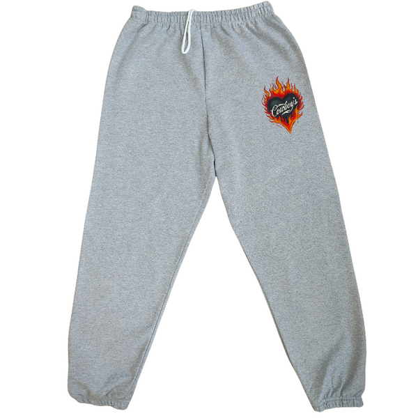 Bring bold western energy to your everyday wardrobe with these Cowboys flame sweatpants. Featuring a striking flaming heart “Cowboys” graphic, these gray jogger-style sweatpants are designed for laid-back comfort with a statement edge. They have an oversized fit for that relaxed, effortlessly look. They feature a drawstring elastic waistband and elastic cuffs for all-day comfort and an easy fit.