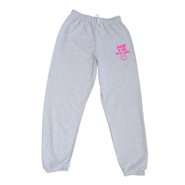Bring all the happy vibes with these trendy “Happy Is the New Rich” smiley face sweatpants. Designed in a classic ash gray and featuring the saying “Happy Is the New Rich” along with a bold neon-pink happy face graphic, these joggers are the perfect mix of comfy, cute, and on-trend. With a relaxed, oversized fit and an elastic waistband, they’re your new everyday go-to. They pair perfectly with our matching sweatshirt (sold separately) to complete the loungewear set — and they also make the perfect gift!