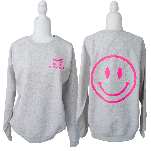Bring all the good vibes with this cozy “Happy Is the New Rich” smiley face sweatshirt. Featuring a bold neon-pink front chest quote and an oversized happy face graphic on the back, this crewneck is designed to make every outfit feel a little brighter. This soft, comfy unisex crewneck makes the perfect gift and for everyday wear, this is your new go-to layer for errands, lounging, weekend adventures, and everything in between. Pair it with our matching sweatpants (sold separately) for the full set. 