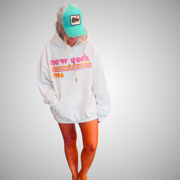 This New York Hoodie is the perfect blend of retro style and everyday comfort. Featuring a distressed New York graphic with vibrant pink and orange stripes, metallic gold beaded drawstrings, and a cozy unisex fit, it's a statement hoodie made for city lovers, travelers, and anyone who loves a bold vintage-inspired aesthetic. Size up 1–2 sizes for a cozy oversized look.