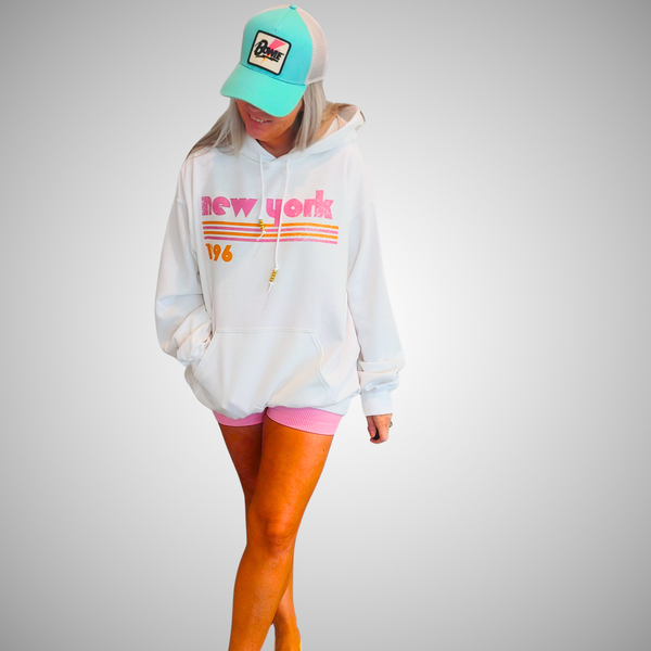 This New York Hoodie is the perfect blend of retro style and everyday comfort. Featuring a distressed New York graphic with vibrant pink and orange stripes, metallic gold beaded drawstrings, and a cozy unisex fit, it's a statement hoodie made for city lovers, travelers, and anyone who loves a bold vintage-inspired aesthetic. Size up 1–2 sizes for a cozy oversized look.