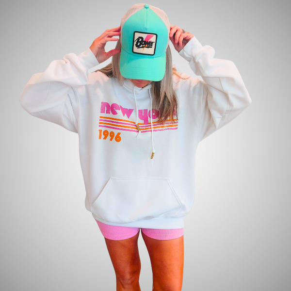 This New York Hoodie is the perfect blend of retro style and everyday comfort. Featuring a distressed New York graphic with vibrant pink and orange stripes, metallic gold beaded drawstrings, and a cozy unisex fit, it's a statement hoodie made for city lovers, travelers, and anyone who loves a bold vintage-inspired aesthetic. Size up 1–2 sizes for a cozy oversized look.