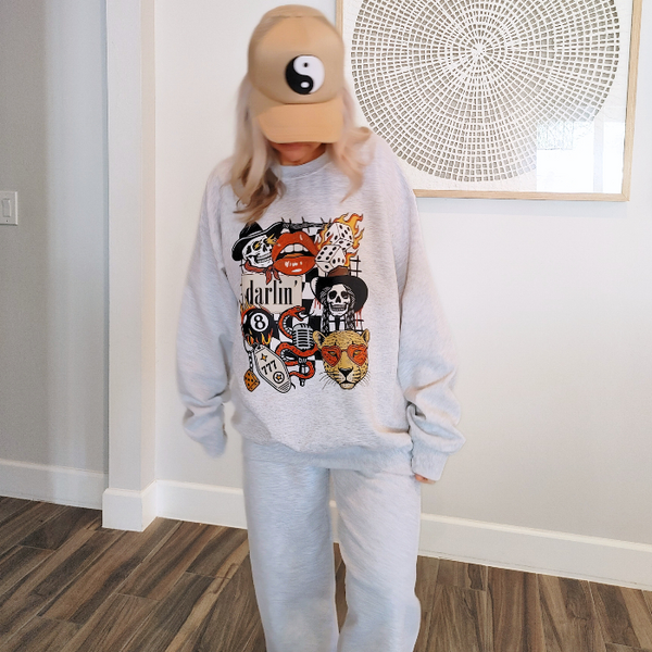 This Western tattoo–inspired matching sweat set includes a bold graphic sweatshirt and coordinating sweatpants featuring cowboy skulls, flaming dice, retro lips, a heart-eyed leopard, and other vintage-style details. Perfect for cozy loungewear with an edgy Western twist. The sweatshirt is 50% cotton / 50% polyester and we recommend sizing up for an oversized fit. The sweatpants are also 50% cotton / 50% polyester, unisex with an oversized fit, and designed with a drawstring elastic waistband, elastic cuffs