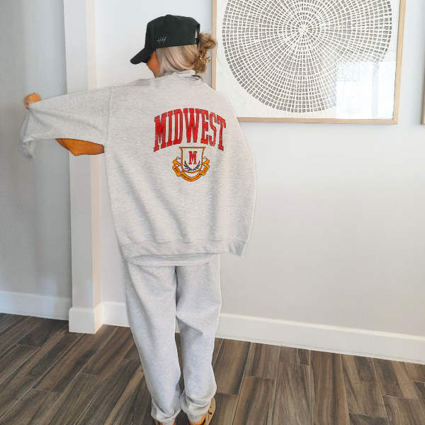 This Midwest T Shirt and Sweatpants Set is the perfect combination of comfort and effortless collegiate style. Featuring a distressed varsity-inspired Midwest graphic on a matching ash gray t-shirt and jogger set, this outfit is ideal for lounging, travel days, running errands, or creating a casual streetwear look you'll wear on repeat with sweatpants that feature a relaxed oversized fit and for a trendy overside t-shirt fit size up. Matching Midwest sweatshirt sold separately, pair all three pieces for the
