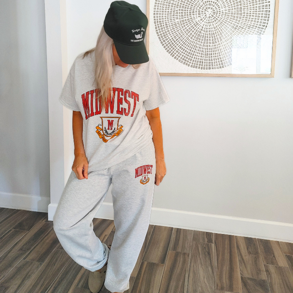This Retro Midwest Graphic Tee brings classic collegiate style and effortless comfort together in one timeless design. Featuring a distressed varsity-inspired "Midwest" graphic on a soft 100% cotton Gildan unisex tee, it's perfect for anyone who loves vintage aesthetics, casual streetwear, and laid-back everyday fashion. Size up for a trendy oversized look.