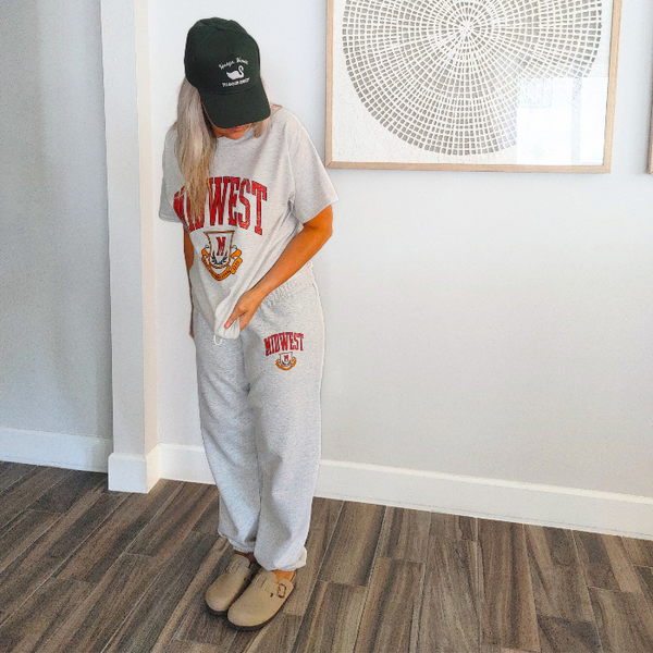 This Retro Midwest Graphic Tee brings classic collegiate style and effortless comfort together in one timeless design. Featuring a distressed varsity-inspired "Midwest" graphic on a soft 100% cotton Gildan unisex tee, it's perfect for anyone who loves vintage aesthetics, casual streetwear, and laid-back everyday fashion. Size up for a trendy oversized look.