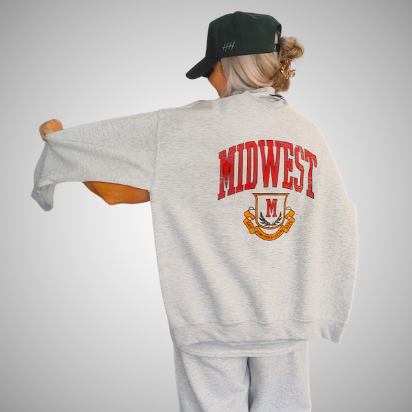 This Midwest Sweatshirt and Sweatpants Set combines cozy comfort with classic collegiate style. Featuring a distressed varsity-inspired Midwest graphic on a matching ash gray crewneck and jogger set, this outfit is perfect for travel days, casual weekends, running errands, or relaxing in ultimate comfort. Sweatpants feature a relaxed oversized fit, and for an oversized fit size up in our crewneck. Matching Midwest graphic t-shirt sold separately.