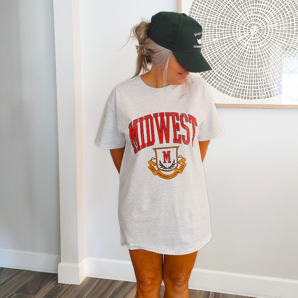 This Retro Midwest Graphic Tee brings classic collegiate style and effortless comfort together in one timeless design. Featuring a distressed varsity-inspired "Midwest" graphic on a soft 100% cotton Gildan unisex tee, it's perfect for anyone who loves vintage aesthetics, casual streetwear, and laid-back everyday fashion. Size up for a trendy oversized look.